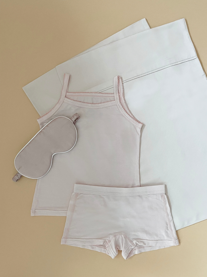 Spoil little ones with this Limited Edition Feel Good Snoozin’ Gift Set curated in collaboration with NakedLab. Each set includes Just Peachy TENCEL™ Micro Modal Top & Bottom, NakedLab Bamboo Silk Kids Pillowcase and a luxurious sleep mask for a peaceful night’s rest. Shop now. Pink color gift set for kids.